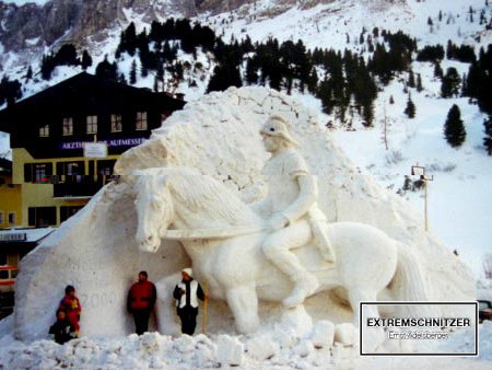 Ein römischer Legionär auf seinen Pferd. Eine Skulptur komplett aus Eis und Schnee. Zum Größenvergleich stehen einige Menschen davor.